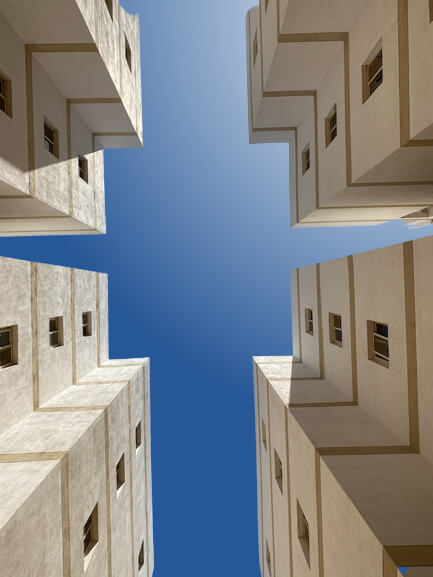 This example uses the gradient background mode to add a background that simulates a sky with sun rays. It utilizes a radial gradient, which is well-suited for the circular shape of the sun, and positions its center in the top-right corner (so that shadows on buildings correspond to the direction of the sun rays). In the center of the gradient, it uses the white color for the sun, gradually transitioning to the sky blue color #275796. (Source: Pexels.)
