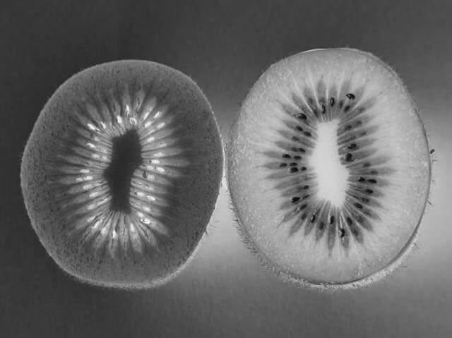 In this example, we invert the black and white colors in a grayscale image of a sliced kiwi. For the inversion effect, we select a circular area with the size of 285 by 335 pixels, and cover the rightmost halve of the kiwi. We then enable the "Select Outside Region" option, which applies the inversion effect to the colors outside of the chosen circular area. (Source: Pexels.)