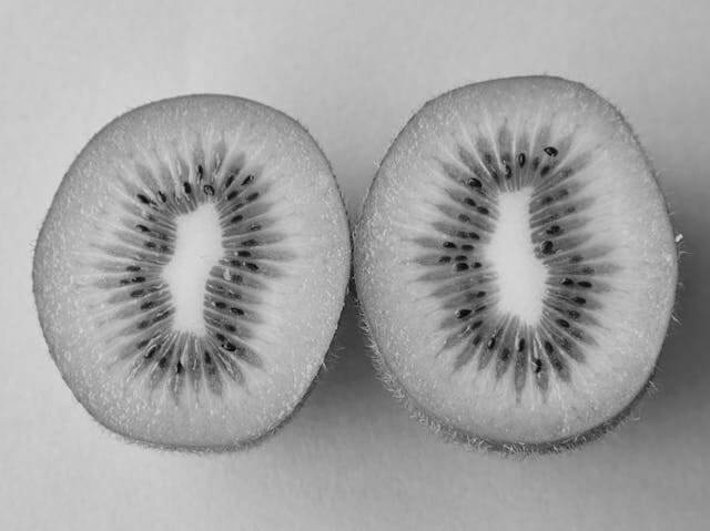 In this example, we invert the black and white colors in a grayscale image of a sliced kiwi. For the inversion effect, we select a circular area with the size of 285 by 335 pixels, and cover the rightmost halve of the kiwi. We then enable the "Select Outside Region" option, which applies the inversion effect to the colors outside of the chosen circular area. (Source: Pexels.)