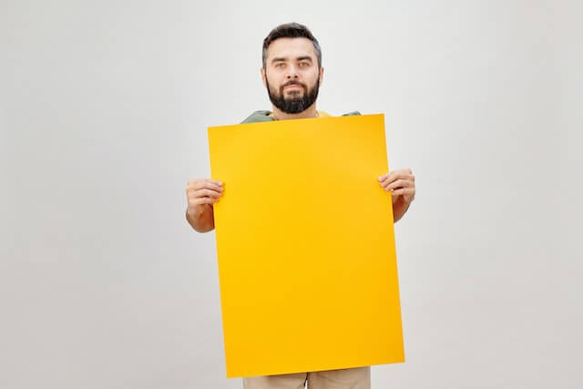 This example removes the yellow region from the parchment that a person is holding. It turns the selected area into a white canvas, on which any ads can now be applied. It uses a color threshold percentage of 12%, which allows us to remove not only the yellow color, but also some similar shades, and it also uses a smoothing radius of 3 pixels. (Source: Pexels.)
