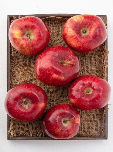 In this example, we transform an image of red apples into three monochrome images, each representing a unique component of the LCH color space. The first image shows the luminance of every pixel (it is black and white by default), the second highlights chroma (originally displayed in magenta and white but turns monochrome upon conversion), and the third represents hue (depicts the vibrant hues of the image in grayscale style). (Source: Pexels.)