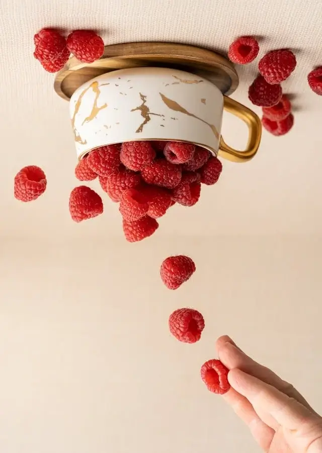 In this example, we vertically flip an artistic WebP photo of raspberries falling into a ceramic cup. This vertical mirroring reverses the photo orientation and creates an illusion that raspberries are not falling downwards but instead are rising upwards. (Source: Pexels.)